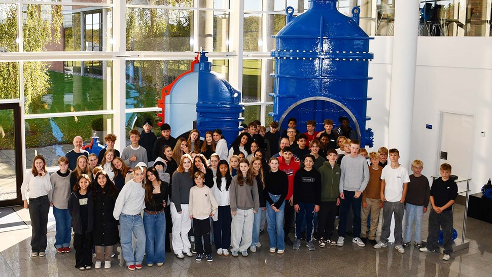 School kids at science day standing in front of a blue valve